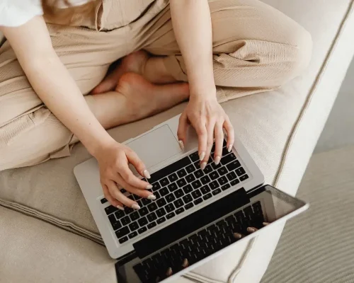 Kobieta pracująca przy laptopie w pozycji siedzącej,